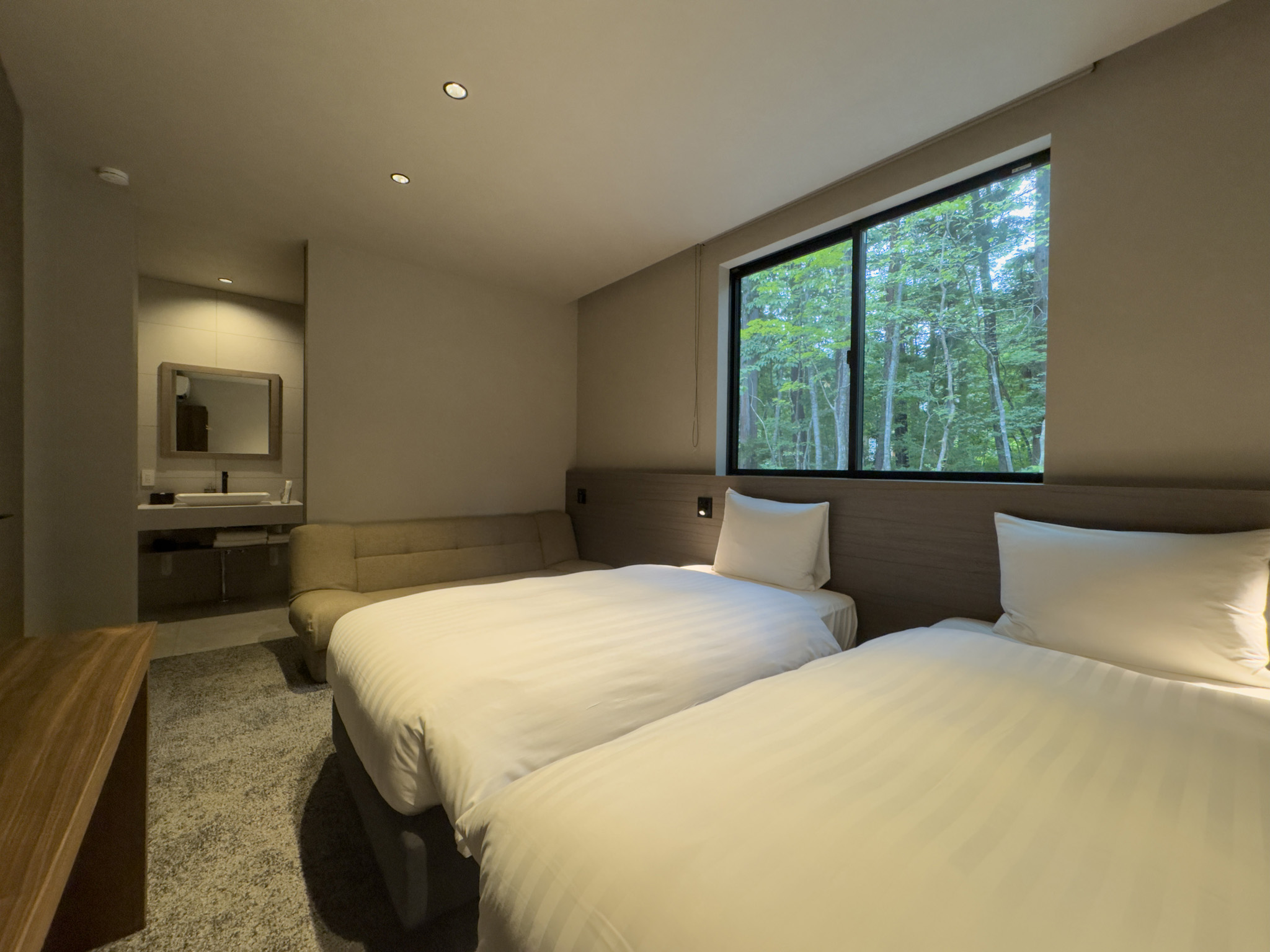 Bedroom 2 with two single beds, a sofa bed and forest views