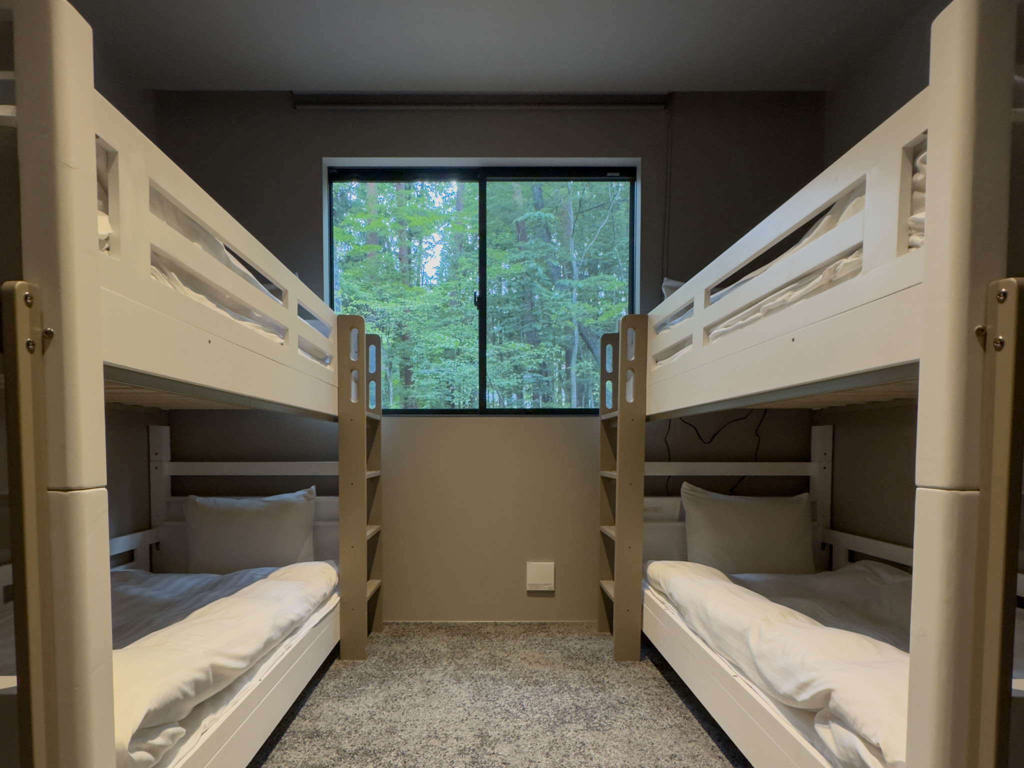 Bedroom 3 with two bunk beds and a window overlooking the forest